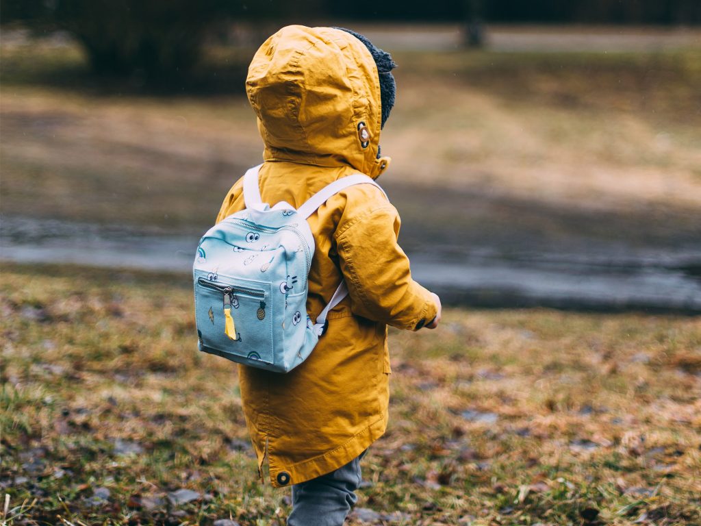 Child walking outside with backpack