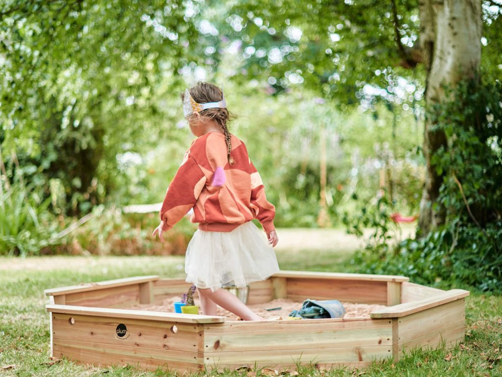 Girl playing in Plum Play Giant Wooden Sandpit 